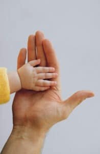 Baby touching parent's hand